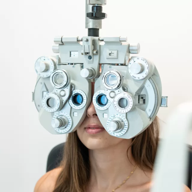 Utente a realizar exame de visão com foróptero (teste de refração)